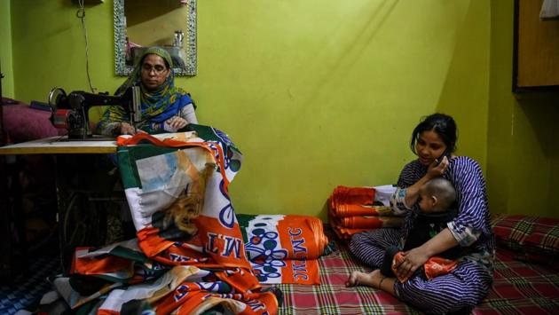 Amra Jahan (L), 46, stitches All India Trinamool Congress party flags at her house ahead of parliamentary elections in the old quarters of Delhi. (Chandan Khanna / AFP) 