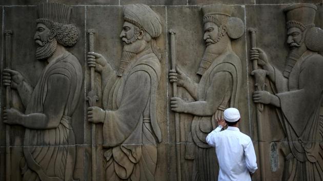 A man touches the wall of a Parsi fire temple featuring huge carvings of ancient priests on the occasion of the Persian New Year or Nowruz in Mumbai, Maharashtra. (Francis Mascarenhas / REUTERS) 