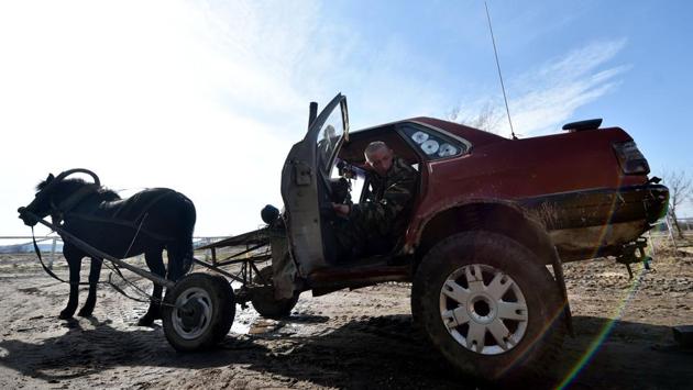 Farmer Alexei Usikov, 31, gets into his horse-pulled cart made from an old Audi 80 car in the village of Slabodka, some 232 km east of Minsk, Belarus. Since he was a child, Alexei Usikov liked to make things. His latest invention is what he calls a “horse mobile” -- a dilapidated red car pulled by a horse that he rides through Belarus’ countryside. (Sergei Gapon / AFP) Farmer Alexei Usikov, 31, gets into his horse-pulled cart made from an old Audi 80 car in the village of Slabodka, some 232 km east of Minsk, Belarus. Since he was a child, Alexei Usikov liked to make things. His latest invention is what he calls a “horse mobile” -- a dilapidated red car pulled by a horse that he rides through Belarus’ countryside. (Sergei Gapon / AFP)