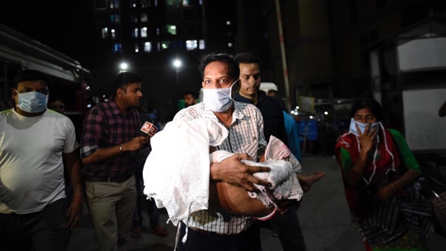 Patients being evacuated after a fire broke out at a basement near the Trauma Centre of the All India Institute of Medical Sciences in New Delhi Sunday evening.(HT PHOTO)
