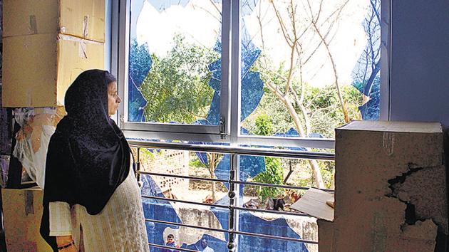 A woman looks through the broken window panes after the attack by locals on Holi, at Bhoop Nagar village, in Gurugram, India, on Saturday, March 23, 2019. The accused had broken the glass window and took out the grill to enter the first-floor terrace.(Yogendra Kumar/HT PHOTO)