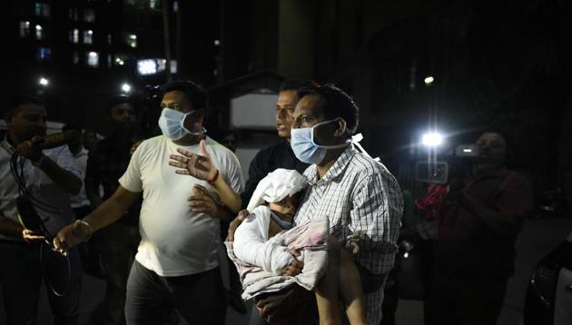 People rescue a patient after fire broke out at the Trauma Centre in AIIMS, New Delhi on March 24, 2019.(Burhaan Kinu/HT PHOTO)