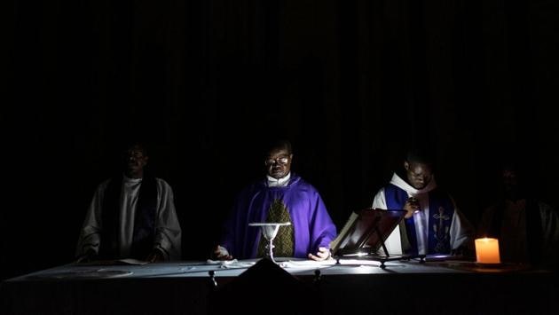 Priests pray during the service at the Ponta Gea Roman Catholic Cathedral in Beira, Mozambique. The church, that sustained minor damages, has no electricity. So they had to use one battery powered light to give light in the church. “The people don’t know what to do because they lost their houses, they have no food, they don’t know where to sleep -- this brings sadness and anxiety,” said Father Pedro. (Wikus De Wet / AFP) Priests pray during the service at the Ponta Gea Roman Catholic Cathedral in Beira, Mozambique. The church, that sustained minor damages, has no electricity. So they had to use one battery powered light to give light in the church. “The people don’t know what to do because they lost their houses, they have no food, they don’t know where to sleep -- this brings sadness and anxiety,” said Father Pedro. (Wikus De Wet / AFP)