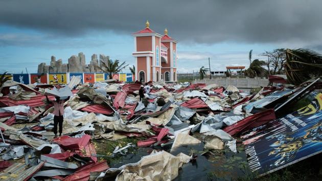 People collect metal sheets from a damaged supermarket to re-build their destroyed houses in Beira. More than two million people have been affected in Mozambique, Zimbabwe and Malawi where the storm started as a tropical depression causing flooding which caused casualties and displaced nearly a million people. Hundreds are still missing in Mozambique and Zimbabwe. (Yasuyoshi Chiba / AFP) People collect metal sheets from a damaged supermarket to re-build their destroyed houses in Beira. More than two million people have been affected in Mozambique, Zimbabwe and Malawi where the storm started as a tropical depression causing flooding which caused casualties and displaced nearly a million people. Hundreds are still missing in Mozambique and Zimbabwe. (Yasuyoshi Chiba / AFP)