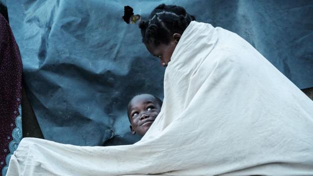 Maria Armando, 30, and her son Fernando Emmanuel, 5, wake up as they stay in shelter at the stands of Ring ground in Buzi, Mozambique. Aid workers from across the world are continuing to arrive in the region to bring help to hundreds of thousands of affected people across an area of roughly 3,000 square kilometres. (Yasuyoshi Chiba / AFP) Maria Armando, 30, and her son Fernando Emmanuel, 5, wake up as they stay in shelter at the stands of Ring ground in Buzi, Mozambique. Aid workers from across the world are continuing to arrive in the region to bring help to hundreds of thousands of affected people across an area of roughly 3,000 square kilometres. (Yasuyoshi Chiba / AFP)