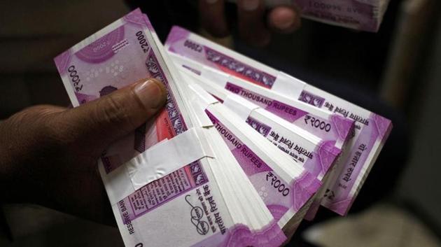 A cashier displays the new 2000 rupee banknotes inside a bank.(REUTERS)