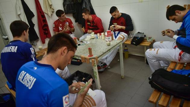 Players, called “pelotari,” can spend an hour before a match preparing their hands. They coat their fingers and palms with a wax covering that they first heat up with a flame. Then they wrap each finger in layers of tape and some thin foam padding to reduce the risk of injury. (Alvaro Barrientos / AP) Players, called “pelotari,” can spend an hour before a match preparing their hands. They coat their fingers and palms with a wax covering that they first heat up with a flame. Then they wrap each finger in layers of tape and some thin foam padding to reduce the risk of injury. (Alvaro Barrientos / AP)