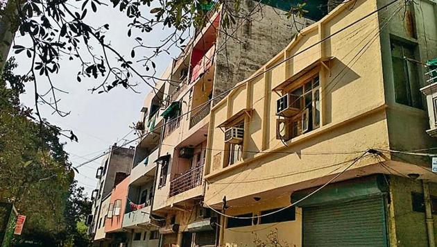 The woman threw her son first from the terrace on the road and then her daughter on the roof of the adjacent yellow building on Monday.(HT Photo)