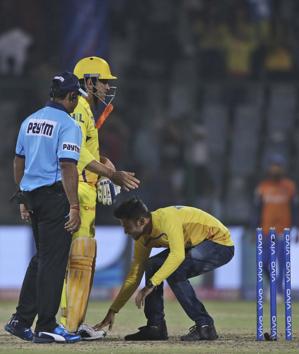 A fan touches the feet of Chennai Super Kings captain MS Dhoni after CSK won the match by six wickets. (AP)