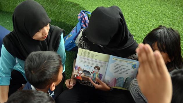 Eventually, parents -- and even the street gangs -- warmed to the idea. Today, it’s not uncommon to see up to 70 kids attending after-school sessions, where they read stories, get help with homework, or sing and dance on concrete covered with green Astroturf. Bookshelves are stuffed with hand-me-down kids’ books and some other less likely titles such as “Accounting” and “Glossary of Marketing Terms”. (Adek Berry / AFP) Eventually, parents -- and even the street gangs -- warmed to the idea. Today, it’s not uncommon to see up to 70 kids attending after-school sessions, where they read stories, get help with homework, or sing and dance on concrete covered with green Astroturf. Bookshelves are stuffed with hand-me-down kids’ books and some other less likely titles such as “Accounting” and “Glossary of Marketing Terms”. (Adek Berry / AFP)