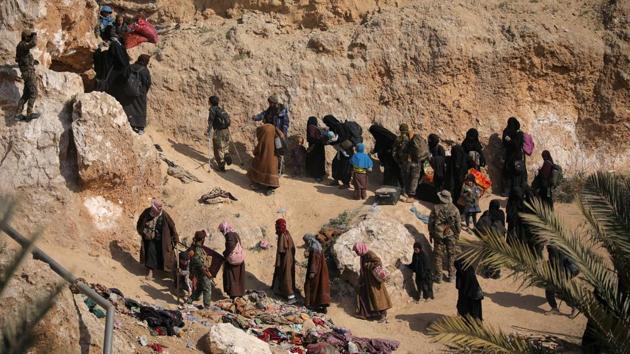Islamic state fighters and their families walk as they surrendered in the village of Baghouz on March 12, 2019. In the end, they were holed up in a tiny enclave from which they released a video showing fighters still shooting with smoke billowing above - an attempt to portray their last stand as heroic and a call to arms for future jihadists. (Rodi Said / REUTERS) Islamic state fighters and their families walk as they surrendered in the village of Baghouz on March 12, 2019. In the end, they were holed up in a tiny enclave from which they released a video showing fighters still shooting with smoke billowing above - an attempt to portray their last stand as heroic and a call to arms for future jihadists. (Rodi Said / REUTERS)