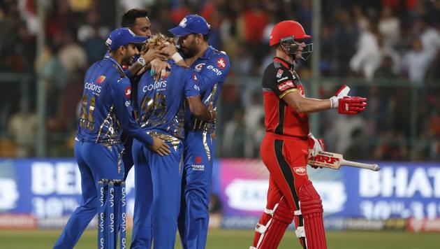 Mumbai Indians' players celebrate after their win as Royal Challengers Bangalore's AB de Villiers, right, walks past (AP) Mumbai Indians' players celebrate after their win as Royal Challengers Bangalore's AB de Villiers, right, walks past (AP)