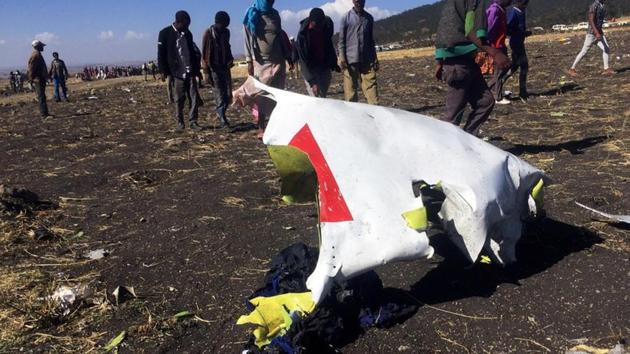 People walk past a part of the wreckage at the scene of the Ethiopian Airlines Flight ET 302 plane crash, near the town of Bishoftu, southeast of Addis Ababa, Ethiopia on March 10.(REUTERS)