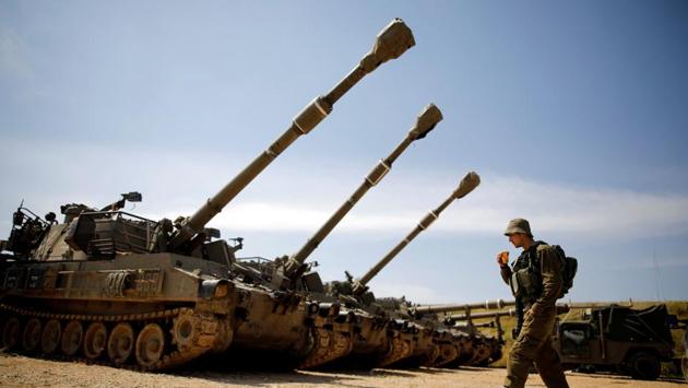 An Israeli soldier walks next to a battery of cannons near the border with Gaza, in southern Israel. (Amir Cohen / REUTERS) An Israeli soldier walks next to a battery of cannons near the border with Gaza, in southern Israel. (Amir Cohen / REUTERS)
