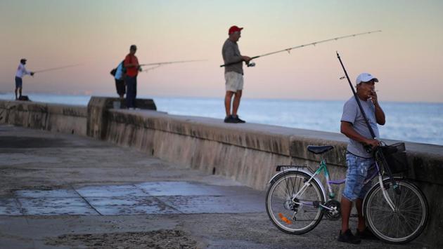 A man smokes a cigarette as people fish on the Malecon in Havana, Cuba. (Phil Noble / REUTERS) A man smokes a cigarette as people fish on the Malecon in Havana, Cuba. (Phil Noble / REUTERS)