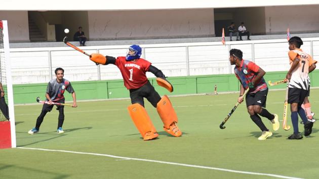 Pimpri Chinchwad Municipal Corporation (goalkeeper) in action against Food Corporation of India Pune during the first edition of Moti John hockey tournament at Dhyan Chand hockey stadium on Thursday.(HT PHOTO)