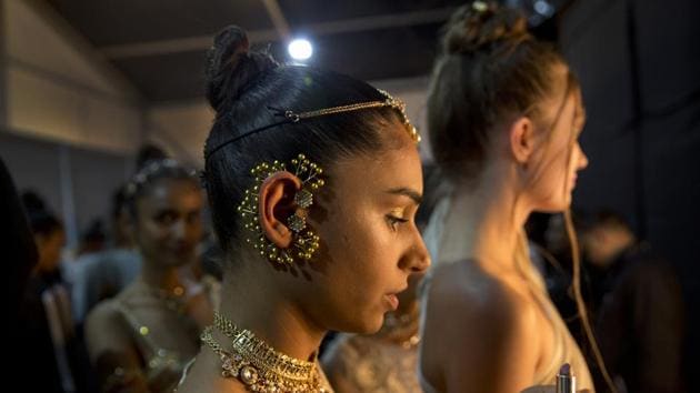 Models touch up their makeup before walking the ramp. “As a long piece of fabric, it’s not easy to drape, a lot of designers have worked on it over time and it is being styled differently to inspire the younger generation to wear,” Vaishali S., a Mumbai-based designer, said of the sari. (Manish Swarup / AP) 