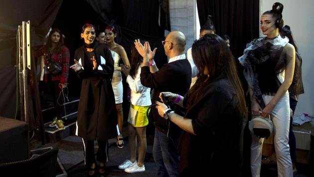 Models, back stage managers and designers applaud at the end of a show. At the end, avid fashionistas in the audience blended in with fashion models as buyers thronged the stalls of designers, who offered their creations for sale, pret-a-porter. (Manish Swarup / AP) 
