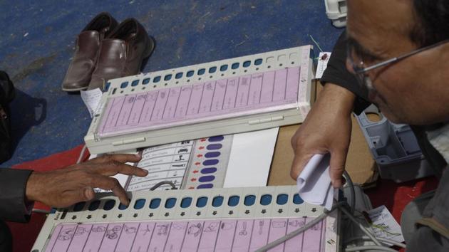 Polling officers check electronic voting machines (EVM) at an EVM distribution centre in Phase 2, Noida.(Burhaan Kinu/HT Photo)