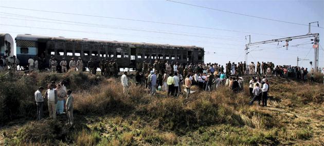 Onlookers gathered near the bogies of Samjhuata Express burnt after an explosion near Panipat, February 19, 2007(PTI)