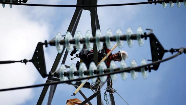A technician works on an electricity pylon as part of the maintenance of high-tension electricity power lines in Wasquehal, France. (Pascal Rossignol / REUTERS) A technician works on an electricity pylon as part of the maintenance of high-tension electricity power lines in Wasquehal, France. (Pascal Rossignol / REUTERS)