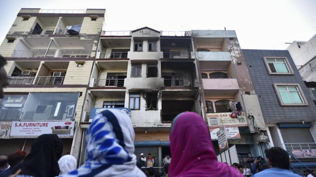 People gather in front of a building that caught fire in at Abul Fazal Enclave Shaheen Bagh, in New Delhi. (Burhaan Kinu / HT Photo) People gather in front of a building that caught fire in at Abul Fazal Enclave Shaheen Bagh, in New Delhi. (Burhaan Kinu / HT Photo)