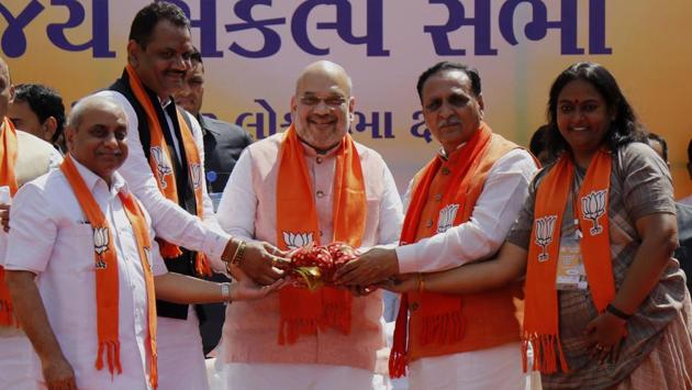Gujarat Chief Minister Vijay Rupani (2nd from R), Deputy Chief Minister Nitin Patel (3rd from L), State Mayor Bijal Patel (R) and Home Minister Rajnath Singh handover a coconut as a goodluck to BJP National President Amit Shah (C) during his public meeting in Ahmedabad on Saturday.(ANI)