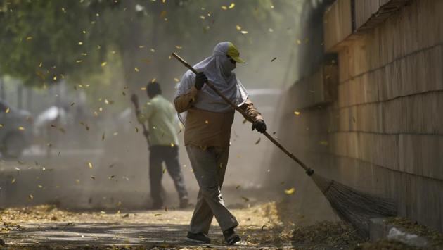 A worker brooms along a service road filled with fallen leaves near Hyderabad House, in New Delhi. (Burhaan Kinu / HT Photo) A worker brooms along a service road filled with fallen leaves near Hyderabad House, in New Delhi. (Burhaan Kinu / HT Photo)