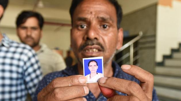 Santosh Kumar with the photo of his wife Suman Devi (36) who was killed in in the bus accident on Yamuna Expressway, on Friday, March 29, 2019.(Virendra Singh Gosain/HT PHOTO)