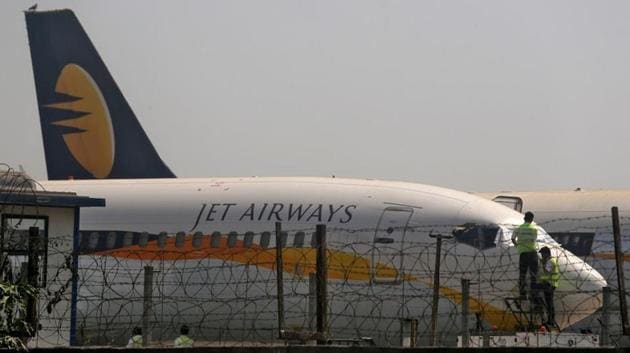 Workers cover the cockpit window of a Jet Airways aircraft parked at the Chhatrapati Shivaji Maharaj International Airport in Mumbai on March 26.(REUTERS)