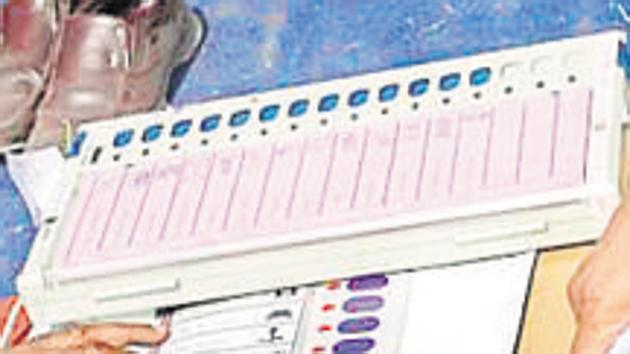 Polling officers check EVMs at an EVM distribution centre.(Burhaan Kinu/HT photo)