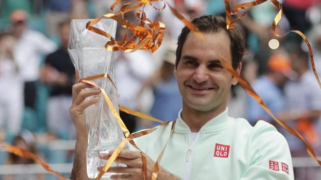 Roger Federer, of Switzerland,holds the trophy after defeating John Isner in the singles final.(AP)