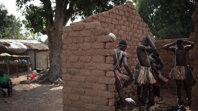 A group of Broto traditional musicians get dressed in a ruined house before performing in Bambari. The musicians, dress in wooden bark clothes called Koundou that help their sway to the tones of the music. (Florent Vergenes / AFP) A group of Broto traditional musicians get dressed in a ruined house before performing in Bambari. The musicians, dress in wooden bark clothes called Koundou that help their sway to the tones of the music. (Florent Vergenes / AFP)