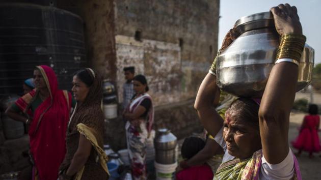 Women in Mardi village in Jalna, Maharashtra line up with water vessels near a borewell in hopes of fetching water. Sakhubai Ghule, 55, a resident of nearby Nandi village, makes her way to the common well before sunrise every day. It is her only hope of getting a bucket of muddy water from the nearly dry well. She gets half a bucket. (Pratik Chorge / HT Photo)