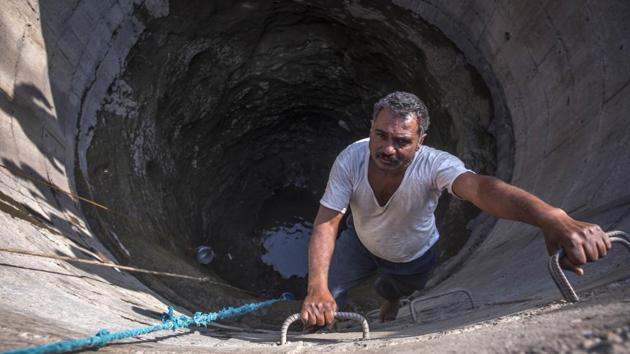 Sheikh Ishaque Ibrahim helps villagers fill buckets by climbing down the well. His task begins at 5 am and goes on for next four hours until the water dips further making it difficult to fill the buckets. In five districts, every village is reeling under drought, according to government figures. (Pratik Chorge / HT Photo)