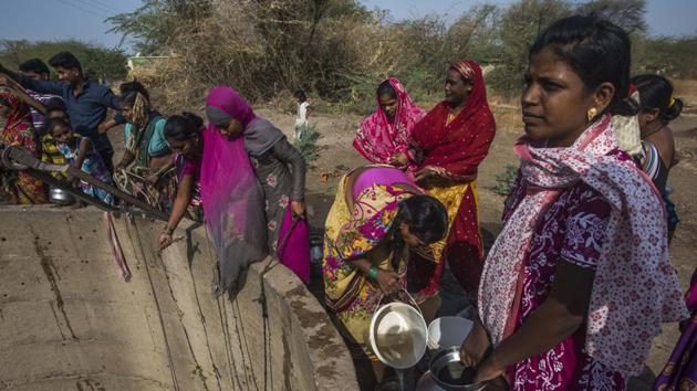 Villagers from Nandi village line by a well where the water level has dipped water significantly and is muddy on top of that. Such sights are commonplace, of villagers seen standing in queues for hours to collect water from tankers, scraping what’s left in their drying wells or doing the rounds of government offices demanding drought-relief. (Pratik Chorge / HT Photo)