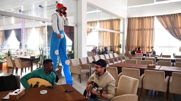 Saied Fadel, 22, and Hamada Nasrallah, 23, of “Solband” rehearse, as a clown on stilts walks by. Solband were not allowed to play at their venue as the ruling Hamas government declined their permit to perform. Often, Martinez said he did not realise what the buildings were because their exteriors gave no sign of what might have been within.. (Dylan Martinez / REUTERS) Saied Fadel, 22, and Hamada Nasrallah, 23, of “Solband” rehearse, as a clown on stilts walks by. Solband were not allowed to play at their venue as the ruling Hamas government declined their permit to perform. Often, Martinez said he did not realise what the buildings were because their exteriors gave no sign of what might have been within.. (Dylan Martinez / REUTERS)