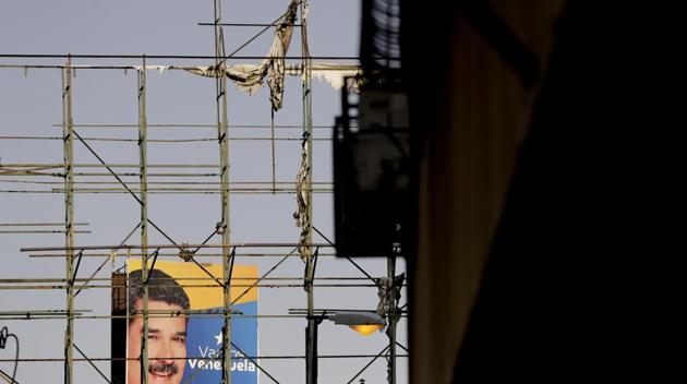 A billboard featuring Venezuela’s President Nicolas Maduro is seen through an empty one. Even under the light of day, billboards often have nothing to promote, their skeletal framework bare long after the wind has ripped away old advertising. (Natacha Pisarenko / AP) A billboard featuring Venezuela’s President Nicolas Maduro is seen through an empty one. Even under the light of day, billboards often have nothing to promote, their skeletal framework bare long after the wind has ripped away old advertising. (Natacha Pisarenko / AP)