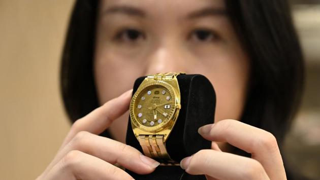 Yean Han, director of Skea, displays a ‘watch’ paper model, at her workshop in Linkou district in New Taipei City. In recent years, traditional paper incarnations of money and gold bars have given way to the more modern -- paper iPads and mobile phones, washing machines, cars, televisions and credit cards. (Sam Yeh / AFP)