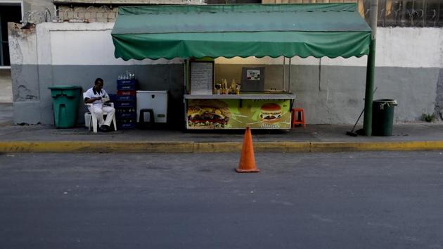 A food vendor waits for customers. Residents avoid stepping outside their homes due to crime — or for lack of anything to spend — as a creeping economic collapse has accelerated amid a political battle between socialist President Nicolas Maduro and his foes at home and abroad. (Natacha Pisarenko / AP) A food vendor waits for customers. Residents avoid stepping outside their homes due to crime — or for lack of anything to spend — as a creeping economic collapse has accelerated amid a political battle between socialist President Nicolas Maduro and his foes at home and abroad. (Natacha Pisarenko / AP)