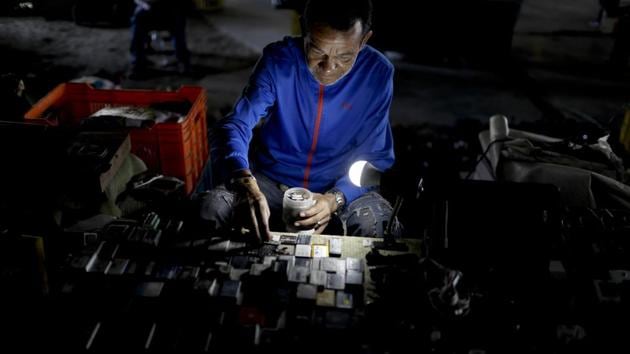 A man lines up used batteries in an attempt to sell them, at a market under a road bridge. Residents desperate for cash have transformed patches of sidewalk into their impromptu shops, laying out old shoes or second-hand shirts as merchandise. (Natacha Pisarenko / AP) A man lines up used batteries in an attempt to sell them, at a market under a road bridge. Residents desperate for cash have transformed patches of sidewalk into their impromptu shops, laying out old shoes or second-hand shirts as merchandise. (Natacha Pisarenko / AP)