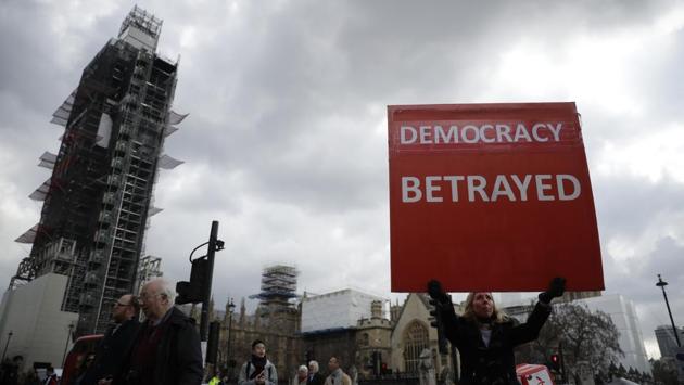 A pro-Brexit supporter holds up a placard backdropped by the Houses of Parliament and a scaffolding-covered Big Ben in London. After failing repeatedly to win Parliament's backing for her Brexit blueprint, Britain's Prime Minister Theresa May dramatically changed gear, saying she would seek to delay Brexit again and hold talks with the opposition to seek a compromise. (Matt Dunham / AP) A pro-Brexit supporter holds up a placard backdropped by the Houses of Parliament and a scaffolding-covered Big Ben in London. After failing repeatedly to win Parliament's backing for her Brexit blueprint, Britain's Prime Minister Theresa May dramatically changed gear, saying she would seek to delay Brexit again and hold talks with the opposition to seek a compromise. (Matt Dunham / AP)