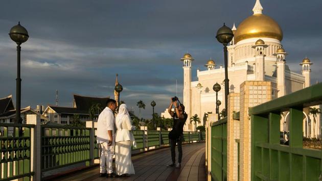 A newlywed couple has their photographs taken at the Sultan Omar Ali Saifuddien mosque in Bandar Seri Begawan, Brunei. The United Nations decried on the new “cruel and inhuman” laws set to take effect in Brunei this week which impose death by stoning for gay sex and adultery, and amputations for theft. (AFP / Brunei OUT) A newlywed couple has their photographs taken at the Sultan Omar Ali Saifuddien mosque in Bandar Seri Begawan, Brunei. The United Nations decried on the new “cruel and inhuman” laws set to take effect in Brunei this week which impose death by stoning for gay sex and adultery, and amputations for theft. (AFP / Brunei OUT)