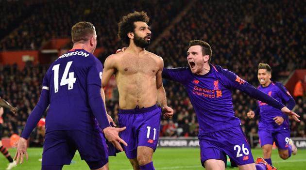 Liverpool's Egyptian midfielder Mohamed Salah (C) celebrates with Liverpool's Scottish defender Andrew Robertson (R) and Liverpool's English midfielder Jordan Henderson (L) after scoring their second goal during the English Premier League football(AFP)