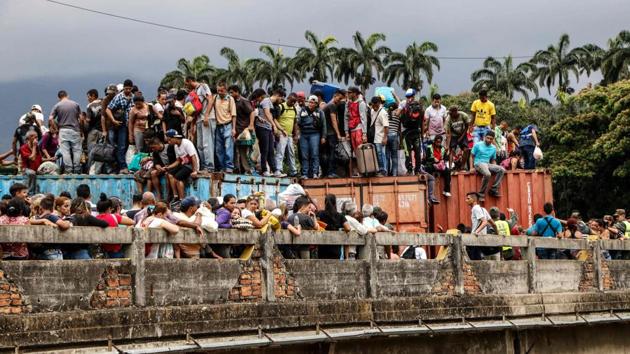 Venezuelans remain on top of containers as they attempt to cross the blocked Simon Bolivar international bridge, in Cucuta, Colombia, along the border with Venezuela. (Schneyder Mendoza / AFP) Venezuelans remain on top of containers as they attempt to cross the blocked Simon Bolivar international bridge, in Cucuta, Colombia, along the border with Venezuela. (Schneyder Mendoza / AFP)