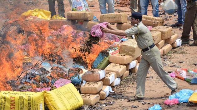 Police tip marijuana onto a fire as they incinerate some 4,572 kilos of the drug worth about 70 million rupees (1 million USD) in Agartala, Tripura. (Arindam Dey / AFP) Police tip marijuana onto a fire as they incinerate some 4,572 kilos of the drug worth about 70 million rupees (1 million USD) in Agartala, Tripura. (Arindam Dey / AFP)