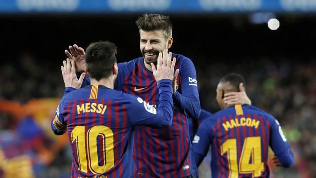 Barcelona's Argentinian forward Lionel Messi is congratulated for his goal by Barcelona's Spanish defender Gerard Pique (C) during the Spanish league football match between FC Barcelona and Club Atletico de Madrid(AFP)