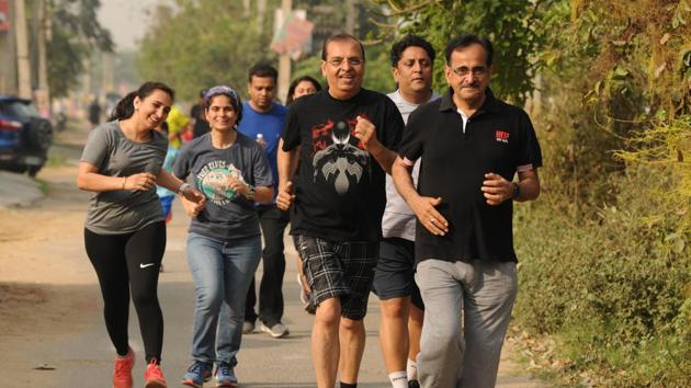 People participate in the 400-metre run during the running workshop organised by Hindustan Times in Sector 52. (Below) Dr Rajat Chauhan interacts with the audience before running.(Parveen Kumar/HT Photo)