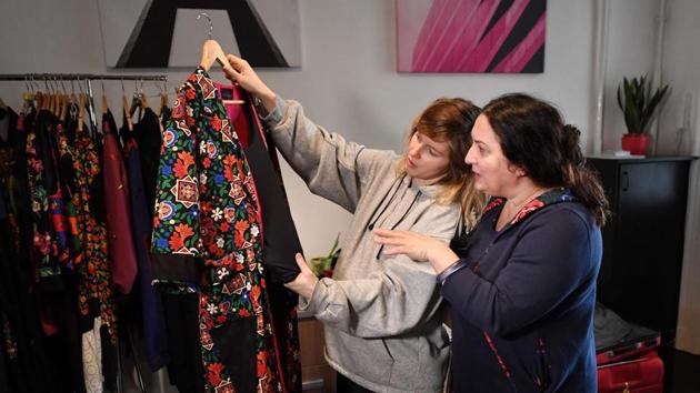 Hungarian Roma fashion designer and founder of “Romani Design” Erika Varga (R) talks with a model before a video and photo shooting for a campaign to promote acceptance of the otherness, dignity, freedom of belief and respect of differences on March 3, 2019 at Romani Design’s studio in Budapest. - Founded in 2010 by Varga to promote Roma fashion and identity, her Romani Design studio brought out its first collection the same year.(ATTILA KISBENEDEK / AFP)