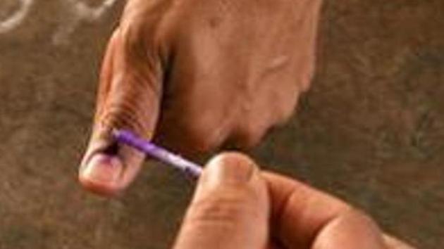 A polling officer marks the finger of a voter with indelible ink at a polling station in a previous election.(AP Photo)